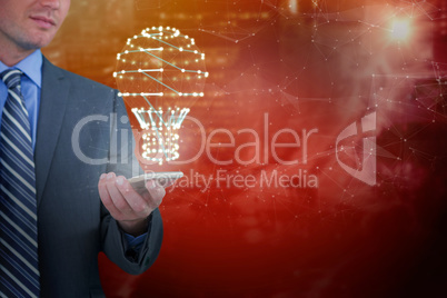 Composite image of businessman holding mobile phone