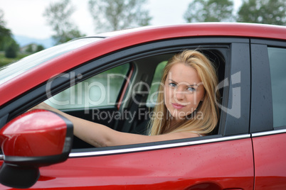 Young girl driving red car