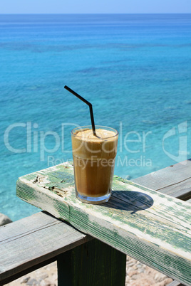 Frappe, ice coffee on grunge wooden rest