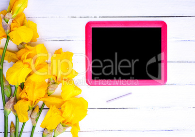 Empty black board in a red frame on a white wooden background