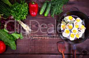 Fried quail eggs in a black cast-iron frying pan