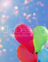 Multicolored balloons against the sky with bright sun