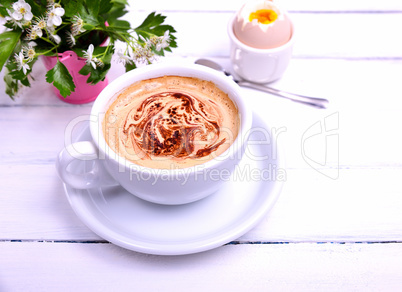 Cup of cappuccino on a white wooden table