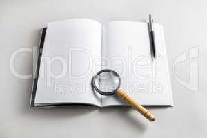 Book, magnifier and pencil