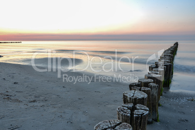 Sonnenuntergang am Meer Ostsee mit Buhnen