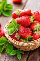 Fresh strawberry in basket on wooden rustic table, closeup. Delicious, juicy, red  berries. Healthy eating.