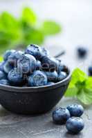 Fresh Blueberries in a bowl on dark background, top view. Juicy wild forest berries, bilberries. Healthy eating or nutrition.