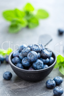 Fresh Blueberries in a bowl on dark background, top view. Juicy wild forest berries, bilberries. Healthy eating or nutrition.