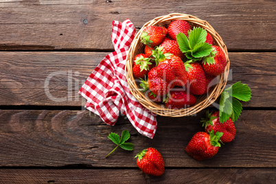 Fresh strawberry in basket on wooden rustic table, closeup. Delicious, juicy, red  berries. Healthy eating.
