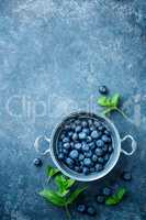 Fresh Blueberries in a bowl on dark background, top view. Juicy wild forest berries, bilberries. Healthy eating or nutrition.