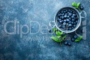 Fresh Blueberries in a bowl on dark background, top view. Juicy wild forest berries, bilberries. Healthy eating or nutrition.