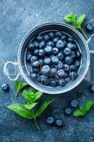 Fresh Blueberries in a bowl on dark background, top view. Juicy wild forest berries, bilberries. Healthy eating or nutrition.