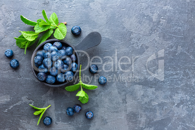 Fresh Blueberries in a bowl on dark background, top view. Juicy wild forest berries, bilberries. Healthy eating or nutrition.