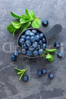 Fresh Blueberries in a bowl on dark background, top view. Juicy wild forest berries, bilberries. Healthy eating or nutrition.