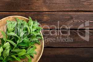Fresh mint leaves on wooden rustic table, top view
