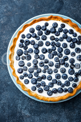 Delicious dessert blueberry tart with fresh berries and whipped cream, sweet tasty cheesecake, berry pie. French cuisine