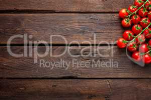 Fresh cherry tomatoes on twigs on wooden table, top view