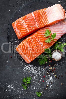 Raw salmon fish fillet on black background