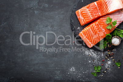 Raw salmon fish fillet on black background