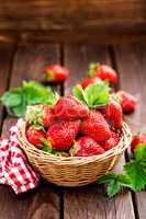 Fresh strawberry in basket on wooden rustic table, closeup. Delicious, juicy, red  berries. Healthy eating.