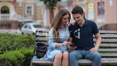 Loving couple sharing media content on smartphone