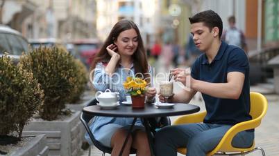 Attractive couple relaxing in sidewalk cafe