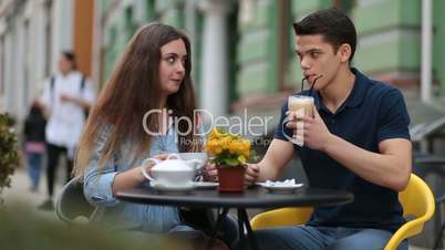 Dating couple relaxing together in street cafe