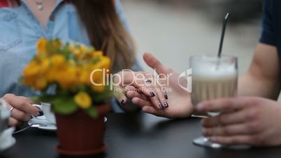 Young couple holding hands at the cafe, closeup