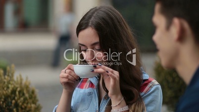 Smiling young woman drinking coffee at cafe