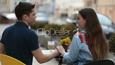 Loving couple sitting at street open-air cafe