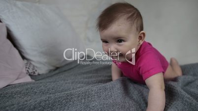 Laughing newborn child playing on bed