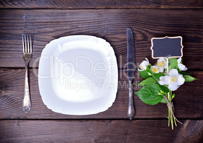 Empty white plate with cutlery