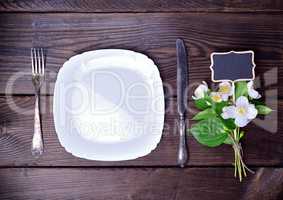 Empty white plate with cutlery