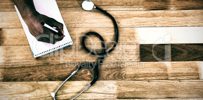 Cropped hand of doctor writing prescription on notepad