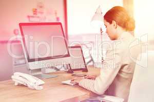 Composite image of serious businesswoman working over computer
