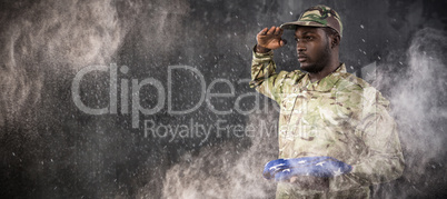 Composite image of portrait of soldier holding american flag and saluting