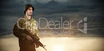 Composite image of full length of soldier holding rifle