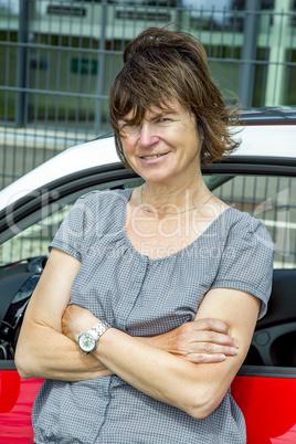 Woman standing in front of car