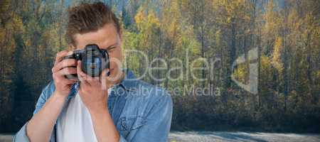 Composite image of young male photographer photographing through digital camera