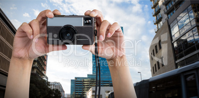 Composite image of cropped hands holding camera