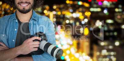 Composite image of portrait of smiling male photographer holding digital camera