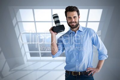 Composite image of portrait of confident photographer holding digital camera