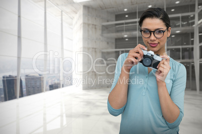 Composite image of portrait of young female photographer with camera standing