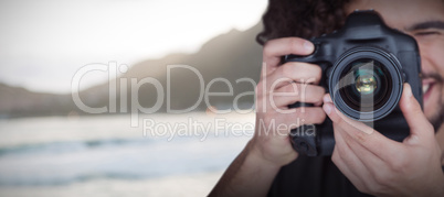 Composite image of close up of male photographer taking picture with camera