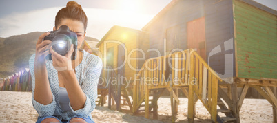 Composite image of young female photographer using digital camera