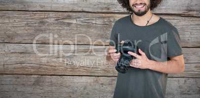Composite image of portrait of happy male photographer holding camera