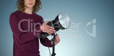 Composite image of portraot of young photographer holding focus light