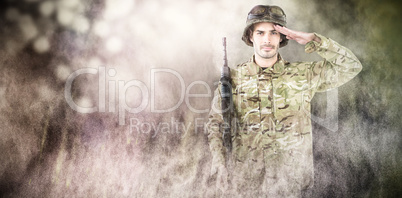 Composite image of portrait of soldier holding rifle and saluting