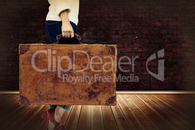 Composite image of low section of woman holding vintage suitcase