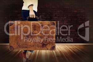Composite image of low section of woman holding vintage suitcase